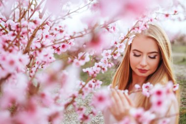 Bahar çiçeklerindeki güzel bir kadının portresi.