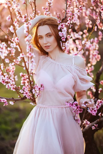 Piękna młoda dziewczyna pod kwitnącym różowym drzewem — Zdjęcie stockowe