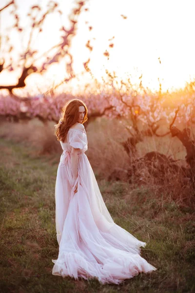美しいです若いです女の子下ザ開花ピンクの木 — ストック写真
