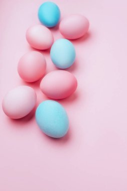 Pembe bir arka plan üzerinde renkli Paskalya yumurtaları.