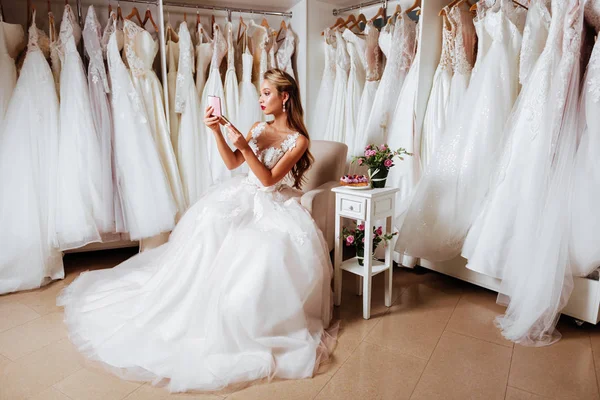 Krásná nevěsta se snaží na elegantní svatební šaty — Stock fotografie