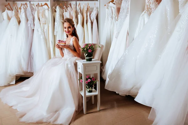 魅力的な若い花嫁はウェディング ドレスを選択しながら笑っています。 — ストック写真