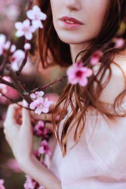 Çiçekli pembe ağacın altında güzel bir genç kız