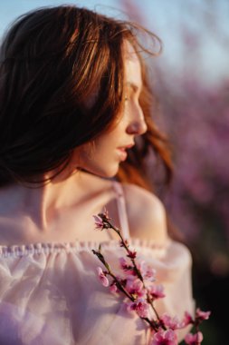 Çiçekli pembe ağacın altında güzel bir genç kız