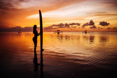 Hint Okyanusu'nda sörf yüzmek için bir dalgıç elbisesi güzel kadın