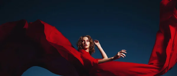 Woman dancing in silk dress, artistic red blowing gown waving and flittering fabric — Stock Photo, Image