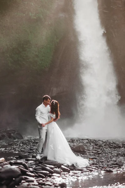 Young couple in love bride and groom, wedding day near a mountain waterfall. — Stock Photo, Image