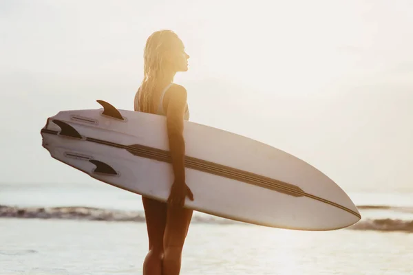 Linda menina surfista sexy na praia ao pôr do sol — Fotografia de Stock