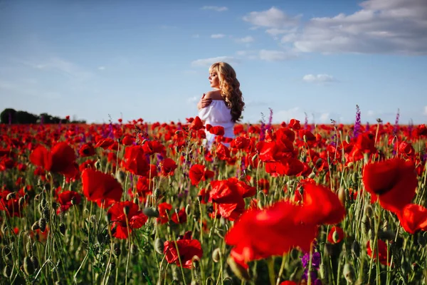 Ragazza allegra con i capelli biondi ricci in un enorme campo di papavero da solo , — Foto Stock