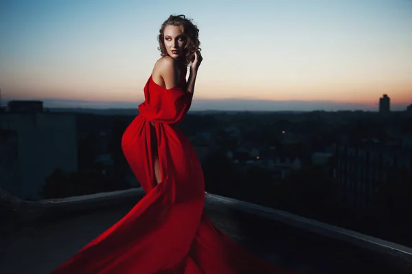 Fashion vogue style portrait of young stunning woman posing in red dress in sunset — Stock Photo, Image