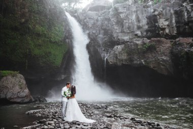 Aşk gelin ve damat genç çift, bir dağ Şelalesi yakınında düğün günü.