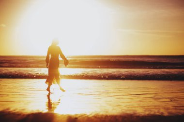 Kumsalda Güzel Günbatımının tadını çıkaran kadın