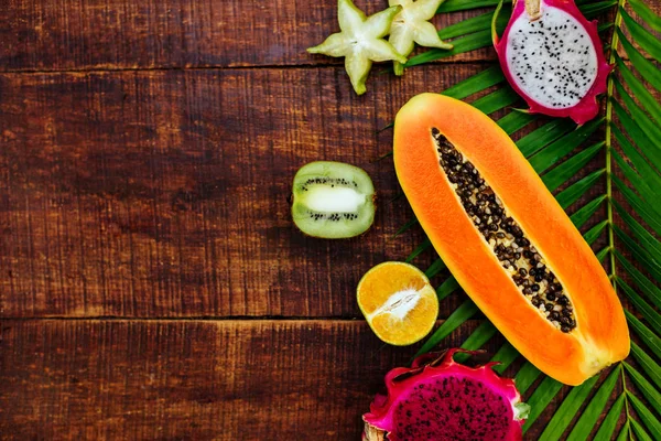 Tropische Früchte auf hölzernem Hintergrund — Stockfoto
