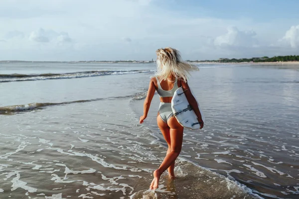 Linda menina surfista sexy na praia ao pôr do sol — Fotografia de Stock