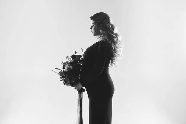 Retrato de una joven embarazada con una gran flor en la mano . — Foto de Stock