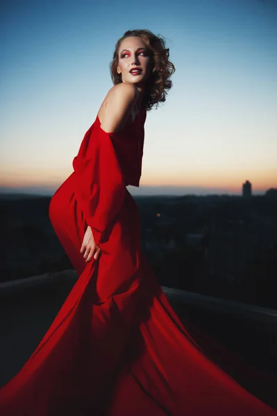 Fashion vogue style portrait of young stunning woman posing in red dress in sunset — Stock Photo, Image