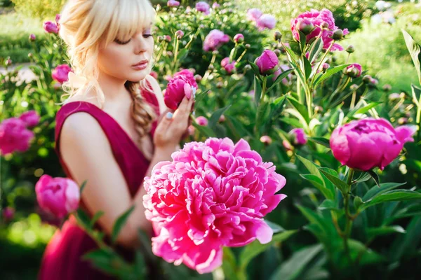 Outdoor close up portrait of beautiful young woman in the blooming garden. Female spring fashion concept