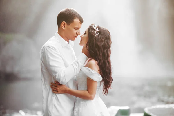 Młoda para w miłości narzeczonej i pana młodego, dzień ślubu w pobliżu górskiego wodospadu. — Zdjęcie stockowe