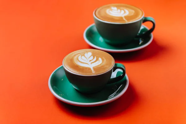 Azurové kávové šálky přes oranžové pozadí. — Stock fotografie