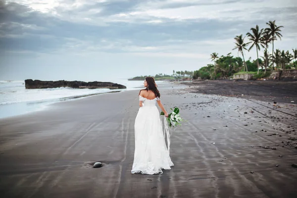 Menyasszony egy strandon a kék víz — Stock Fotó