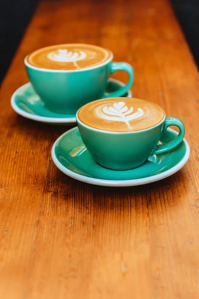 Dos tazas de capuchino sobre fondo de madera . — Foto de Stock