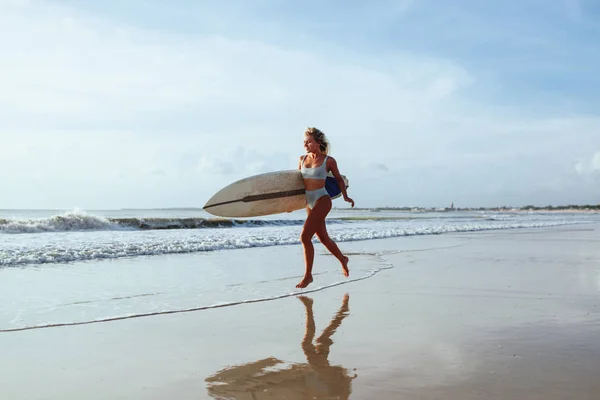 Surfista menina andando com bordo na praia de areia . — Fotografia de Stock