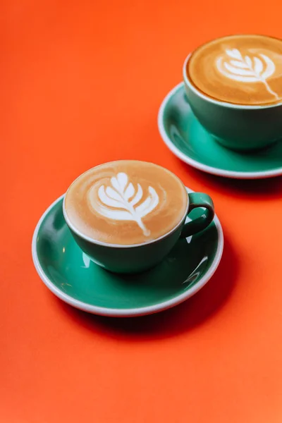 Azurové kávové šálky přes oranžové pozadí. — Stock fotografie