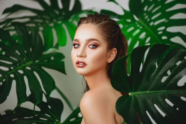 Retrato de mujer joven y hermosa en hojas tropicales . — Foto de Stock