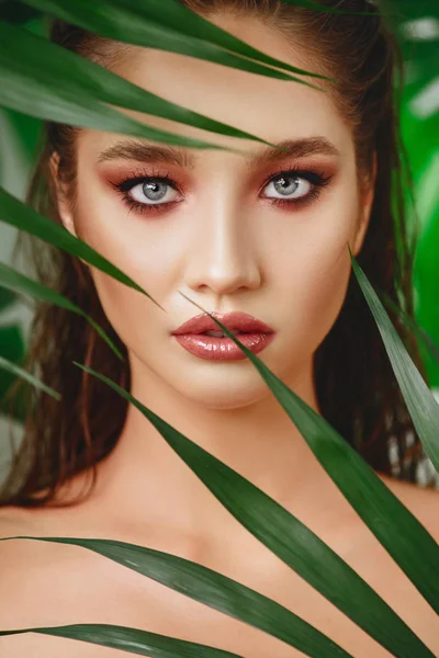 Portrait of young and beautiful woman in tropical leaves. — Stock Photo, Image