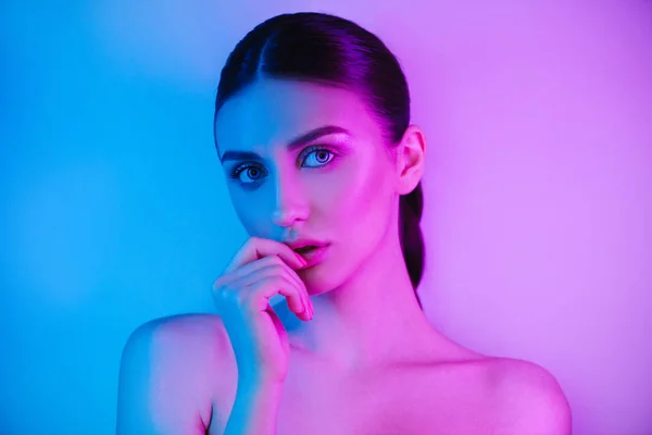 Alta moda mulher em colorido brilhante neon uv azul e roxo luzes, posando em estúdio — Fotografia de Stock