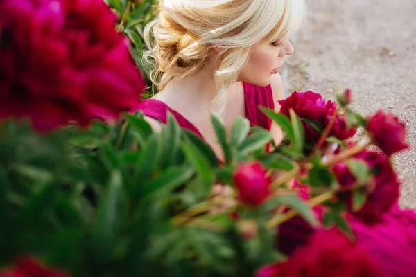 Outdoor close up portrait of beautiful young woman in the blooming garden. Female spring fashion concept