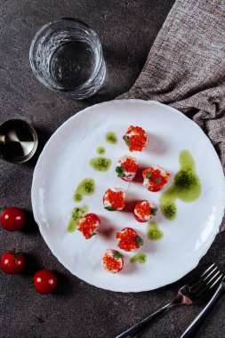 Beyaz bir plaka üzerinde üç dolması domates