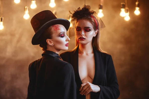 Dwie szczęśliwe młode kobiety w kostiumach czarnej czarownicy halloween — Zdjęcie stockowe