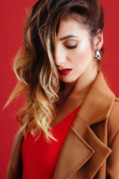 Mode portret van jonge vrouw in jas en rode badpak. — Stockfoto
