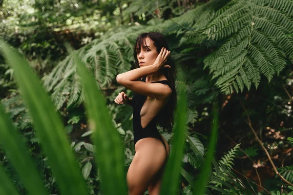 Mujer joven atractiva entre las plantas tropicales. —  Fotos de Stock