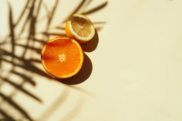 Summer tropical composition. Shadow of palm leaves and tropical fruits on pastel yellow background.