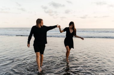 Çekici erkek ve kadın gün batımında romantik bir akşam geçiriyorlar.