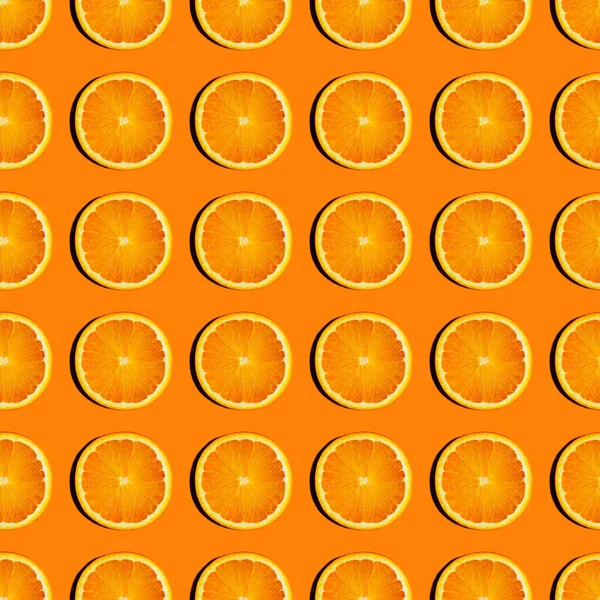 Kleurrijk fruitpatroon van verse sinaasappelschijfjes op gekleurde achtergrond. — Stockfoto