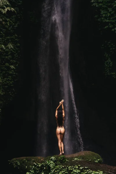 Ung flicka som badar i ett vattenfall — Stockfoto