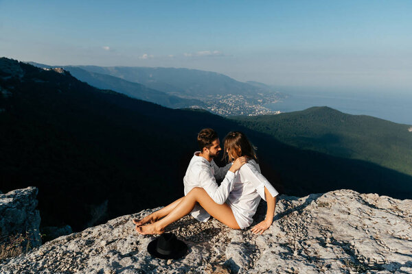 Attractive young loving couple of man and woman in the green mountain landscape