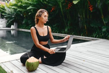 Dizüstü bilgisayarda taze hindistan cevizi ile serbest çalışan bir kadın. .