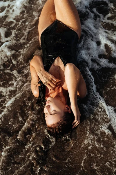 Retrato de una hermosa mujer de moda deportiva en bikini negro posando en verano cerca del océano —  Fotos de Stock