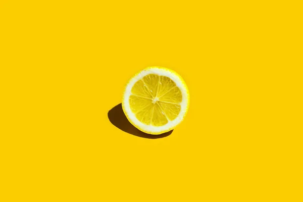 Šťavnatý plátek citronu na žlutém pozadí — Stock fotografie