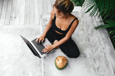 Dizüstü bilgisayarda taze hindistan cevizi ile serbest çalışan bir kadın. .