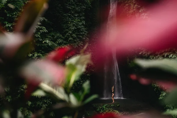 Mladá žena batohem při pohledu na vodopád v džunglích. — Stock fotografie