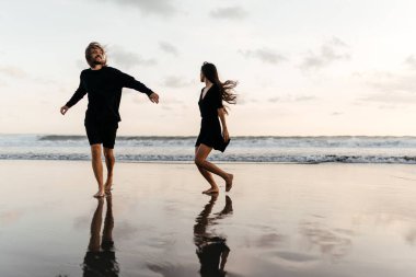 Çekici erkek ve kadın gün batımında romantik bir akşam geçiriyorlar.