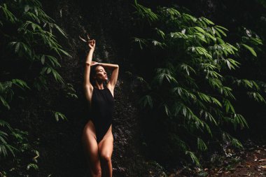 Tropikal bitkiler arasında çekici genç bir kadın..