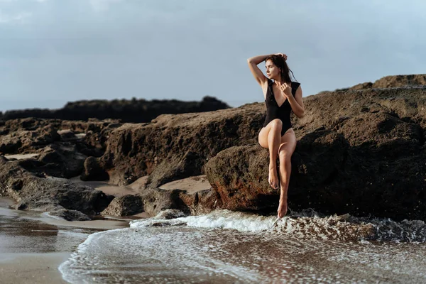 Retrato de mulher bonita moda esporte em biquíni preto posando no verão perto do oceano — Fotografia de Stock