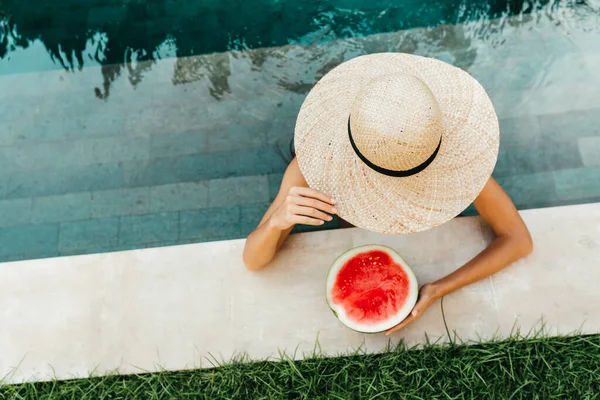 Flicka som håller vattenmelon i den blå poolen, smala ben, instagram stil. — Stockfoto