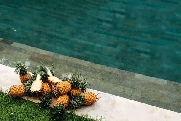 Alimenti biologici crudi sani. Ananas freschi maturi vicino all'acqua pura in piscina. — Foto Stock